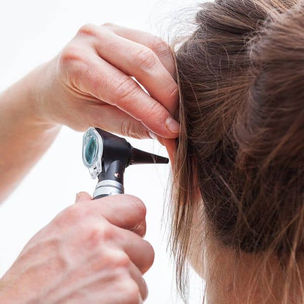 otoscope looking in woman's ear