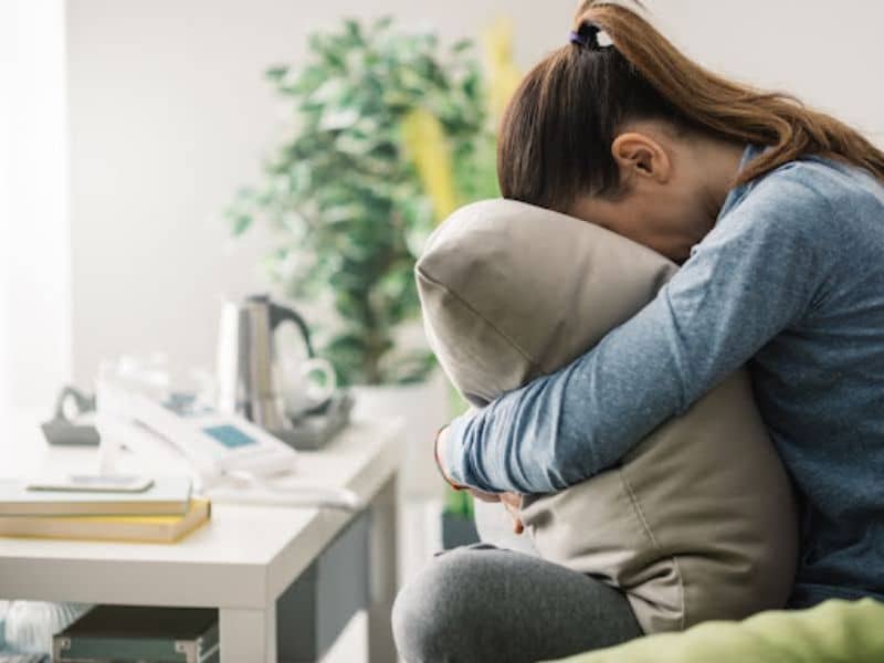 woman crying into a pillow