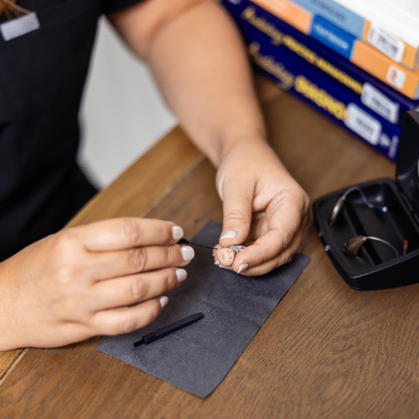 doctor repairing hearing aid